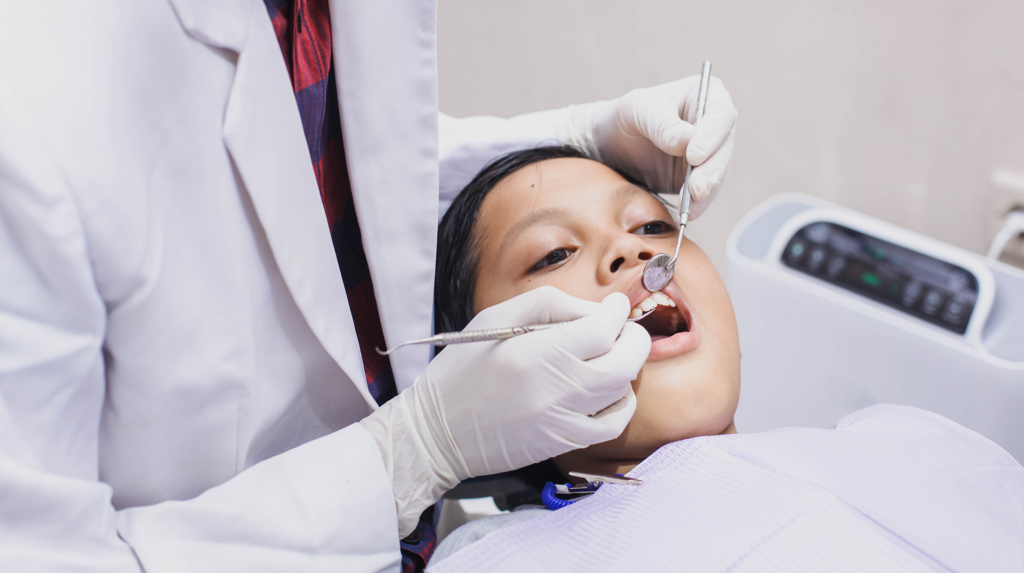 A young boy getting his teeth looked at by an oral surgeon