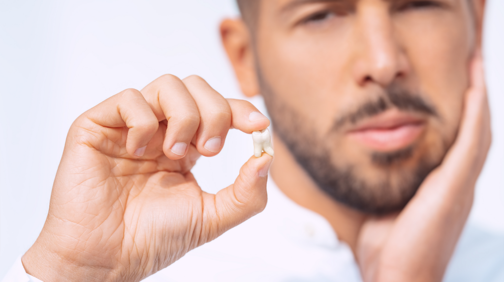 A man holding a tooth