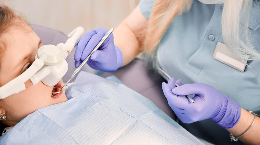 young girl using laughing gas for her oral surgery procedure